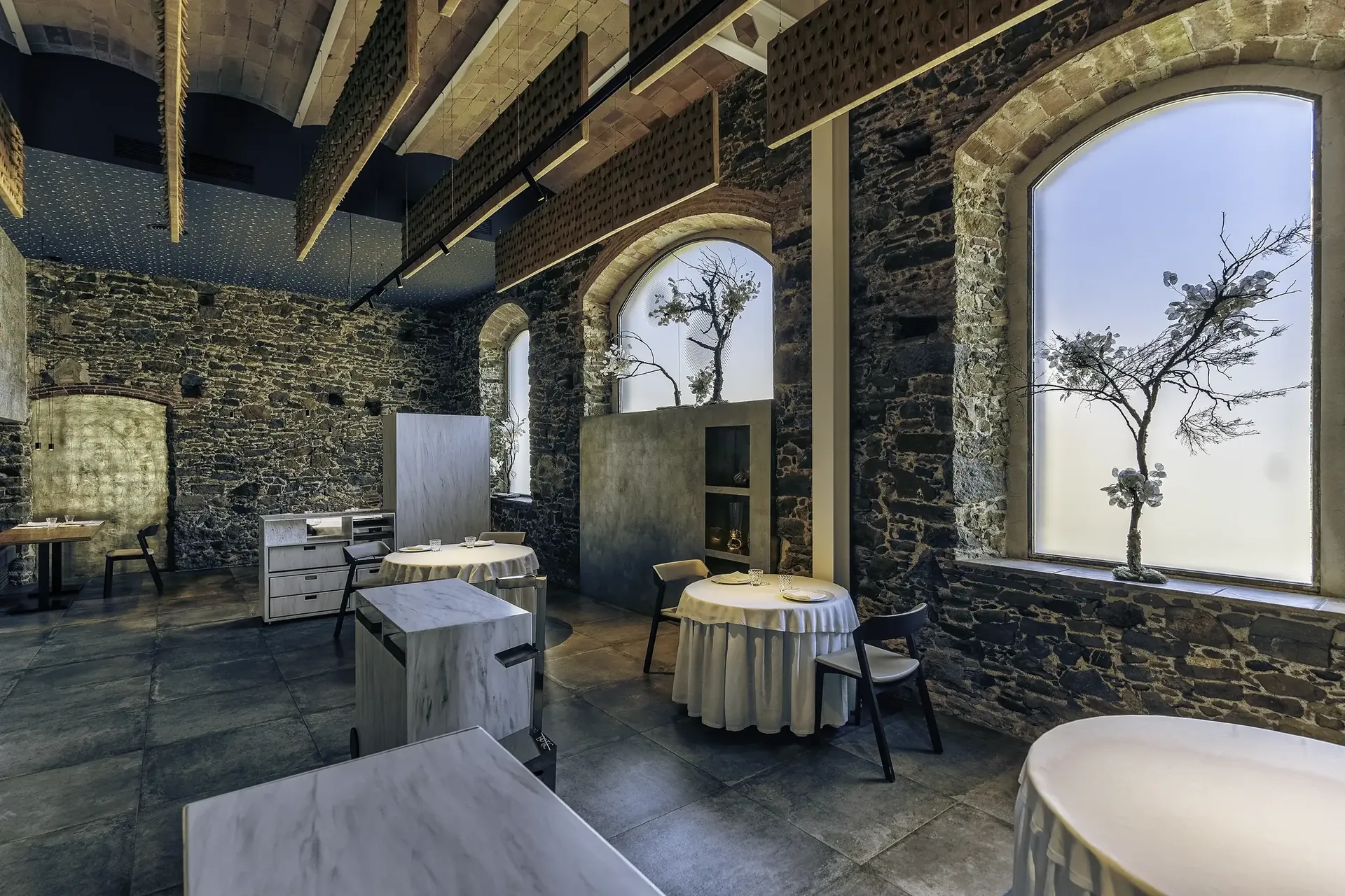 Sala del restaurant Bo.TiC amb parets de pedra i llum natural